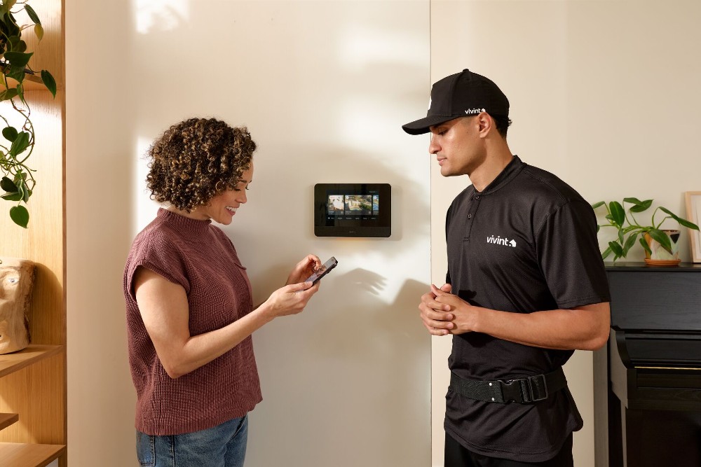 A Vivint technician walking a homeowner through her smart hub setup